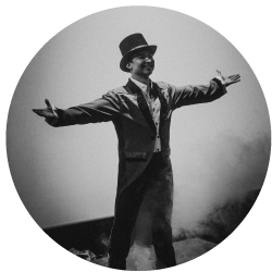 Black and White image of Edmonton School of Ukrainian Dance dancer with a top hat and arms stretched out.